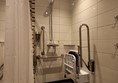 Grab rails around shower seat, unable to reach towels/clothes hooks. No emergency pull cord.