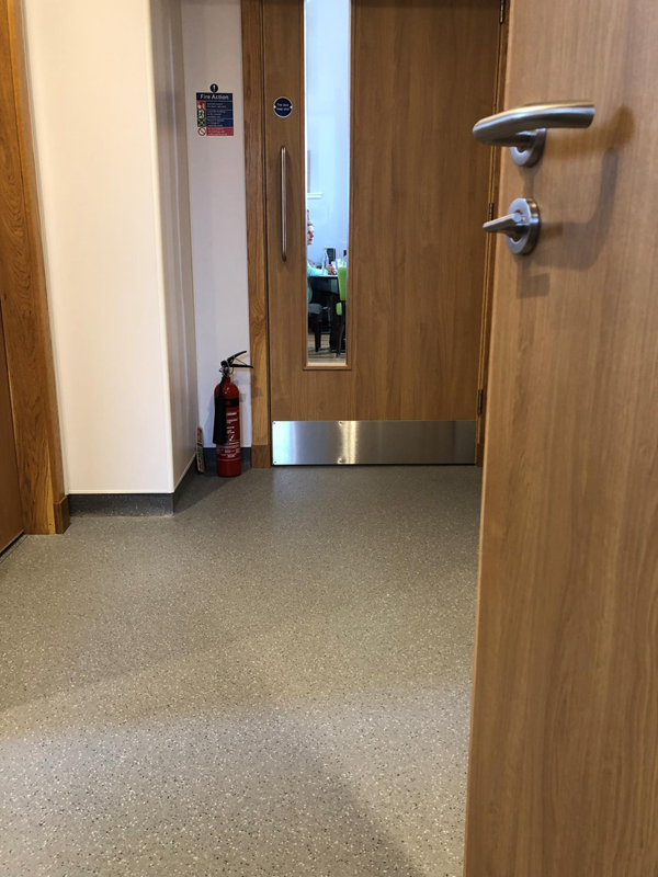 Open door looking towards another door with a thin glass panel on the left hand side
