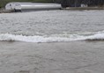 Image of waves, in the distance is a large wave machine