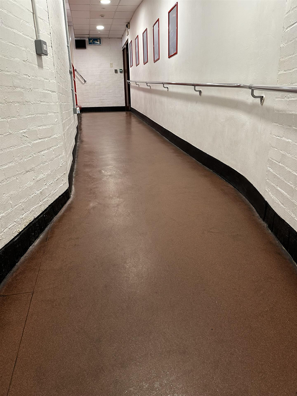 Image of hallway with a gradient with a grab rail on one side