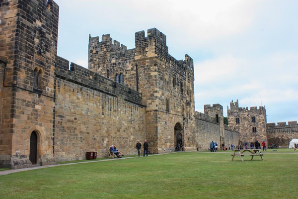 Castle walls from the outside with lawns and a path.