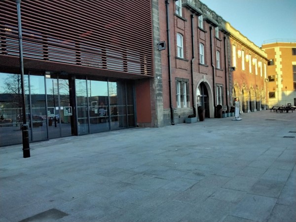 The main entrance is now towards the right of the glass windows, behind which is the bar and auditorium.