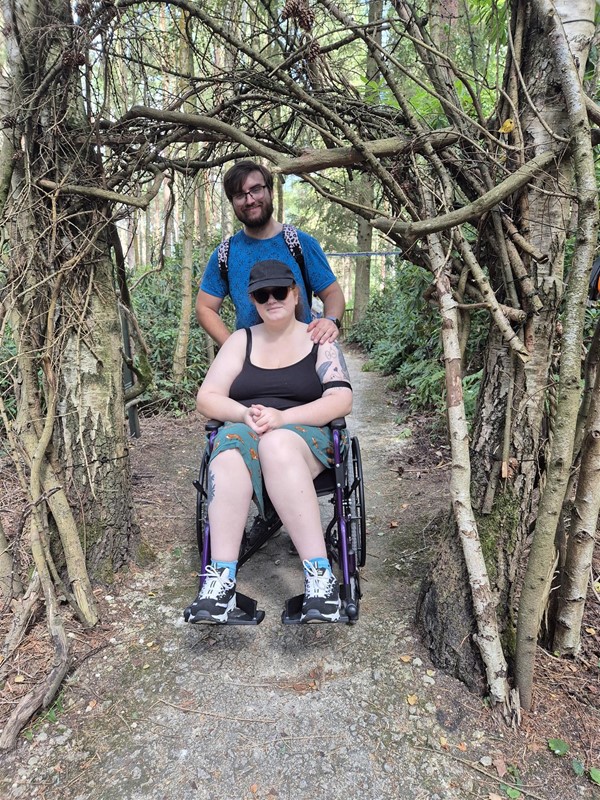 Image of two people under an archway made of trees