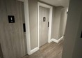 Image of a row of toilet doors in a corridor