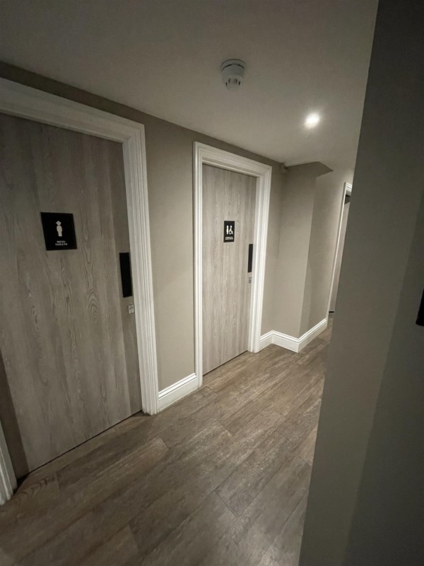 Image of a row of toilet doors in a corridor