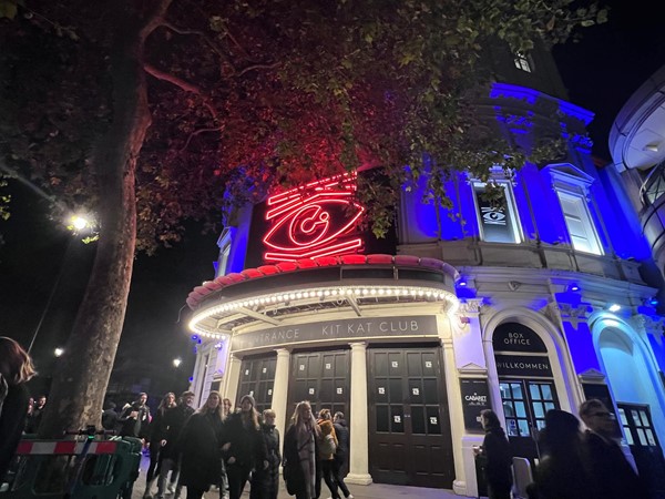 View of outside theatre. Illuminated symbol and underneath written Kit Kat Club