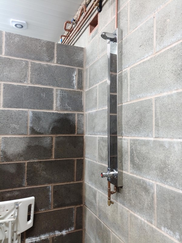 Shower with a press button to time the amount of water you can have.