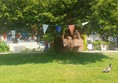 Tree with bunting and a drake exiting camera right