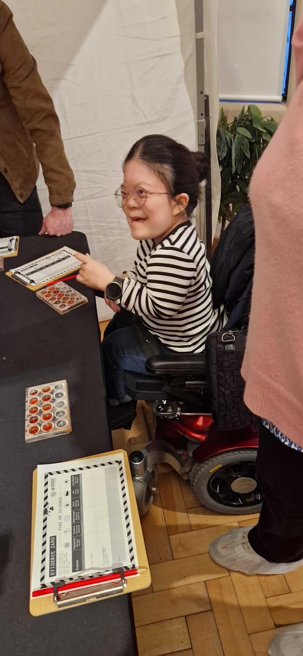 Woman in powerchair at Edinburgh Science Festival event - Crime Scene invesigation, testing fake blood samples.