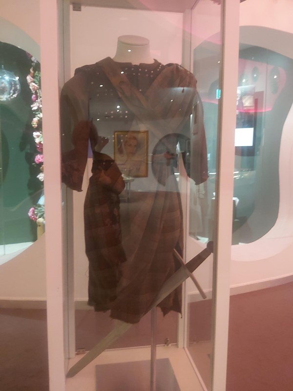 Image of a mannequin with a dress in a glass case