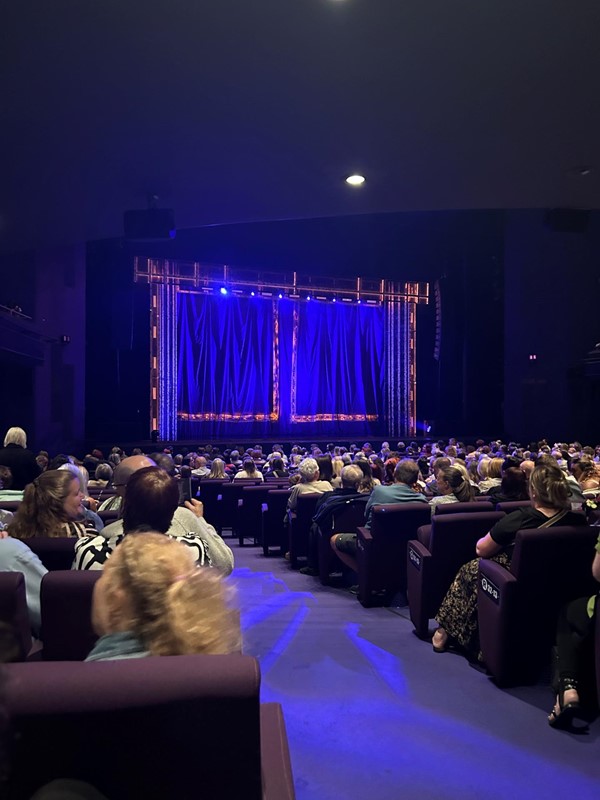 Image of a group of people sitting in chairs in a theatre.