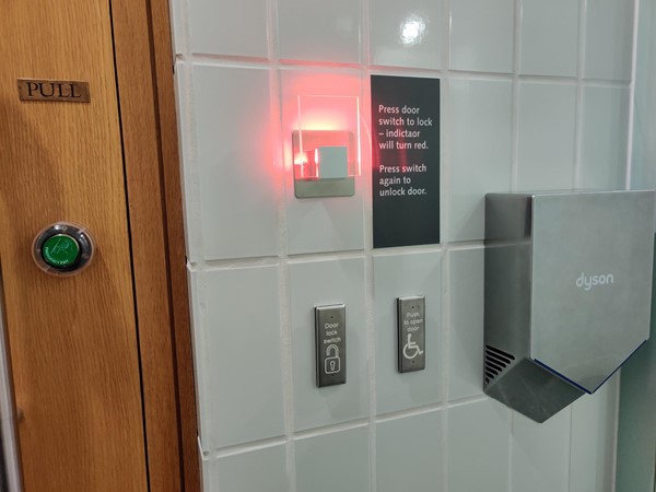 The locking and unlocking buttons and hand-dryer in the accessible toilet.