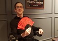 Tom posing under the samurai poster holding a red fan