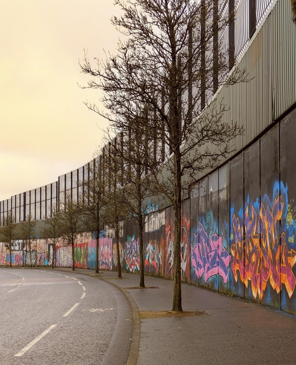 Image of the peace wall and the trees that line it