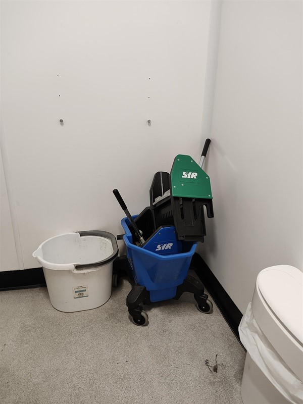 Image of cleaning equipment left inside the toilet room that is easily reached by children etc.