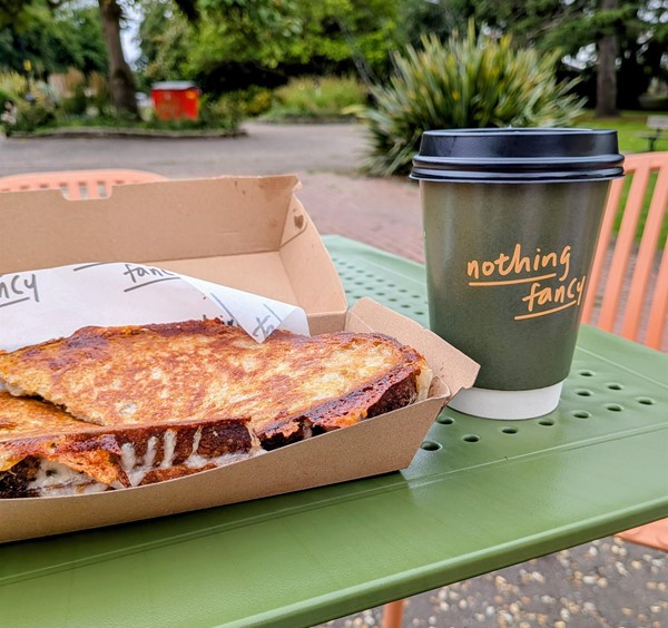 Image of a cheese toastie and a hot drink on a table