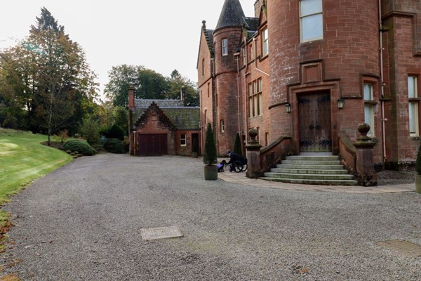 Front of Threave House with gravel but a paved path immediately next to the house.
