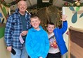 Picture of a man and two boys standing in a corridor