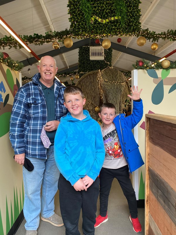 Picture of a man and two boys standing in a corridor