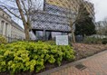 Image of a walkway in the park with the library in the background