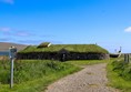 The Viking Longhouse with rough path up to it.