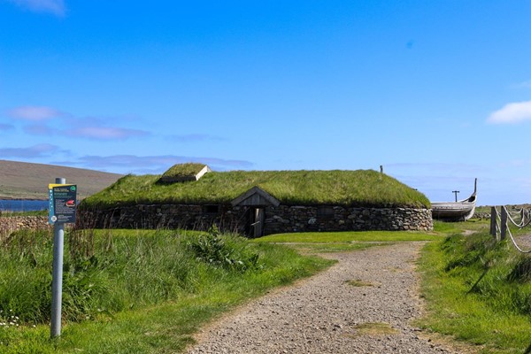 The Viking Longhouse with rough path up to it.