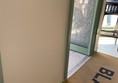 Image of  a metal dog bowl on the floor in between the two doors just inside the entrance.