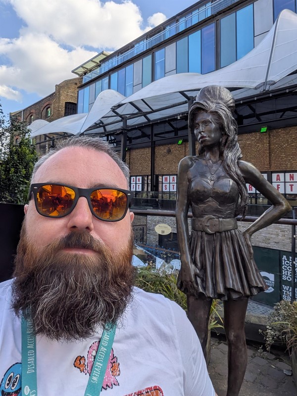 Image of Joe, a white man with short hair and a brown beard with the statue in the background.