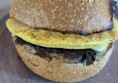 Image of a sausage and omelette bap on a blue plate