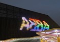 Outside the arena. The word ABBA is lit up in pride flag colours.
