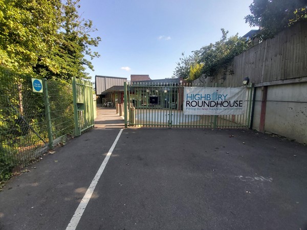 Green gate with a "Highbury Roundhouse" sign
