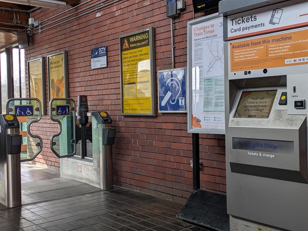 Image of ticket machine, hearing loop symbol and ticket gate