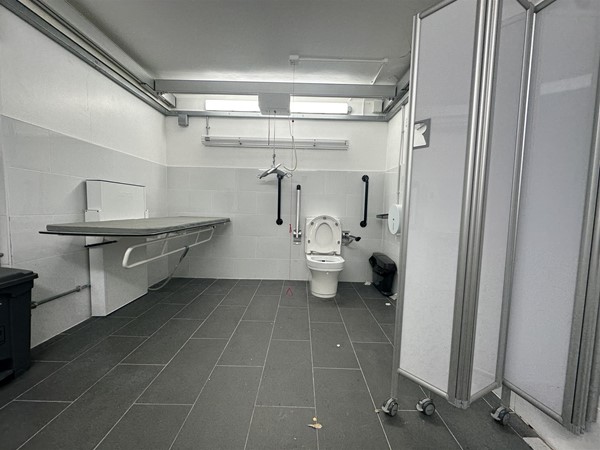 Image of large accessible Changing Places toilet with height-adjustable bench and ceiling hoist