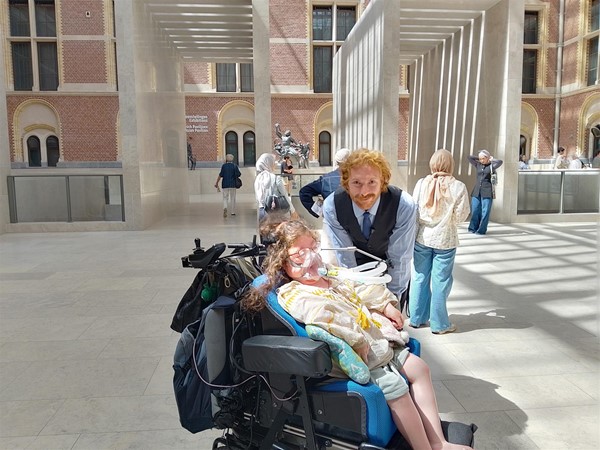 Image of a wheelchair user and a museum attendant