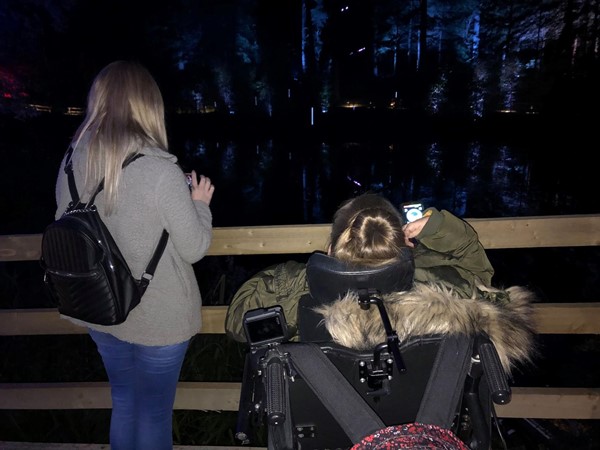 Image of Claire watching the light show over the wooden barrier.