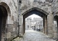 Cobbled path going through castle archway.