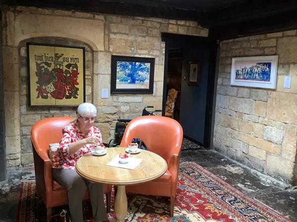 Picture of a person sat at a table having adrink