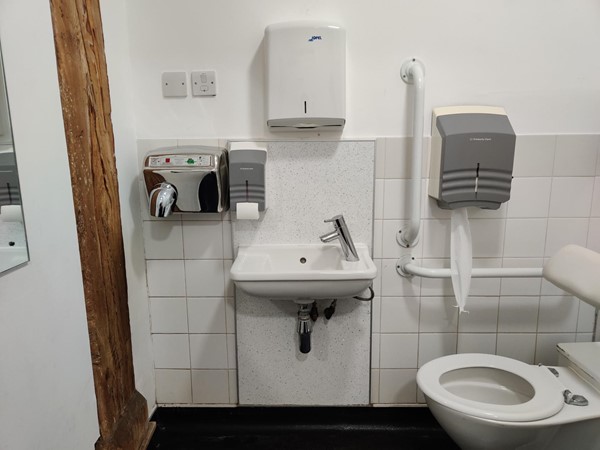 Paper towel dispenser much too high for a wheelchair user to reach, incredibly thoughtless