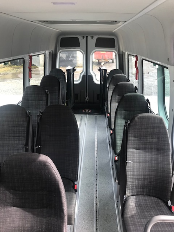 Image showing the inside of the accessible bus from the front seats looking back.