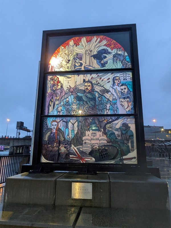 Image of a window by the Riverside showing Jon Snow raising his sword in battle.