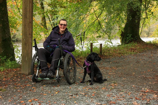 Me and my assistance dog, sitting on the Strid Wood path under the trees.