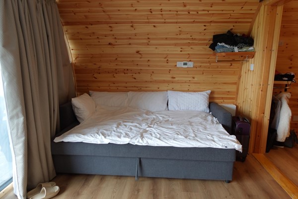 Image of the sofa bed pulled out in the accessible glamping pod.
