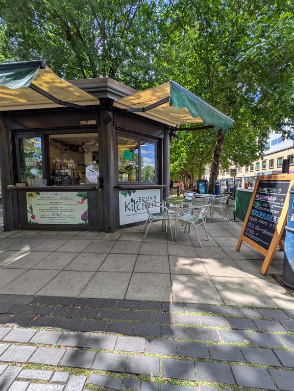 Image of Edna's Kitchen, a kios serving food with some metal seats outside