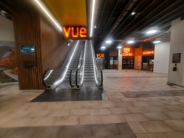 Picture of Vue cinema logo and an escalator