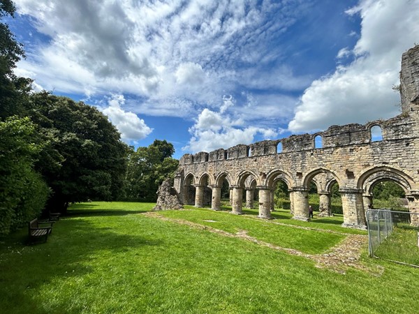 Image of a stone archway with grass and trees
