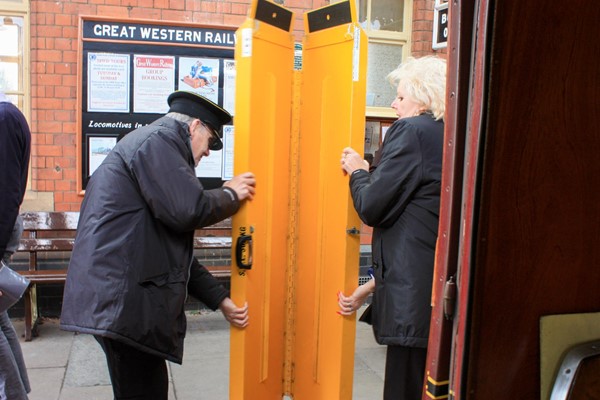 Two members of staff unfolding a ramp