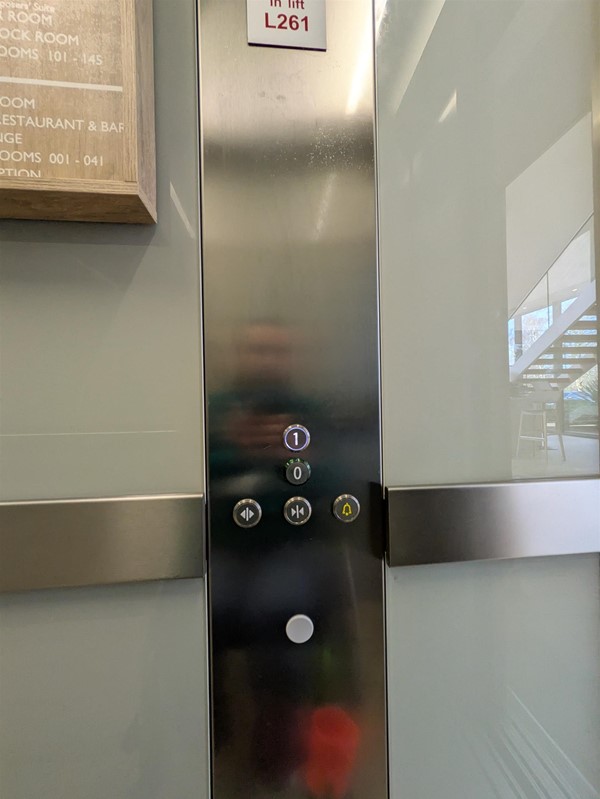 Image of lift buttons. The lift buttons have braille markings