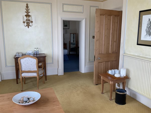 Image of a room with a table, chairs and tea making facilities