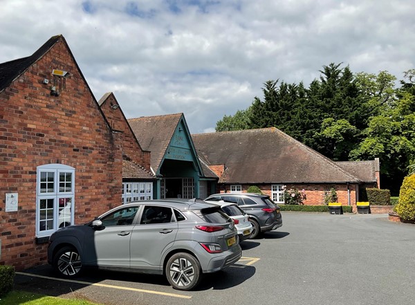 Picture of the front of the hotel and car park