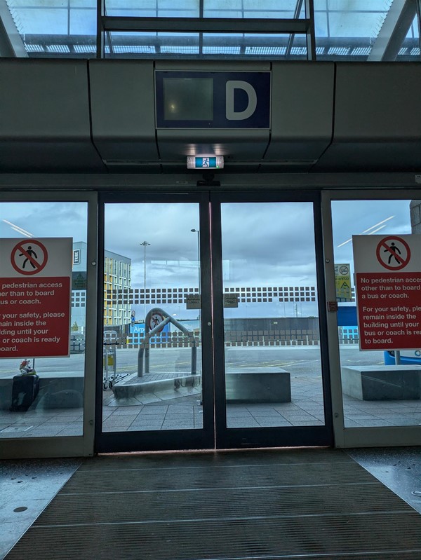 Image of bus station Gate D, automatic doors opening to the bus stops.